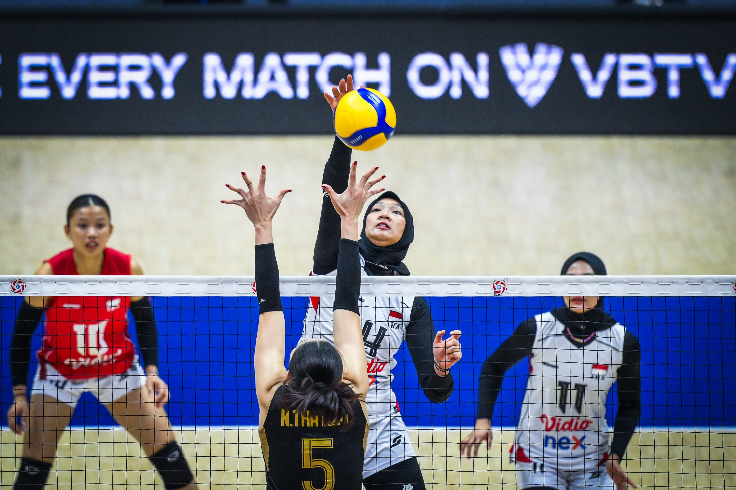 Pemain voli putri Indonesia berusaha memblok serangan lawan saat melawan Thailand di Tianjin Olympic Center Gymnasium, China.
